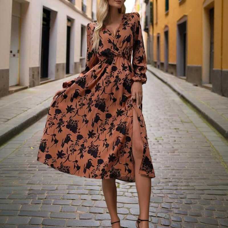 Woman in a floral print V-neck long sleeve maxi dress walking on a cobblestone street, showcasing a stylish side slit.