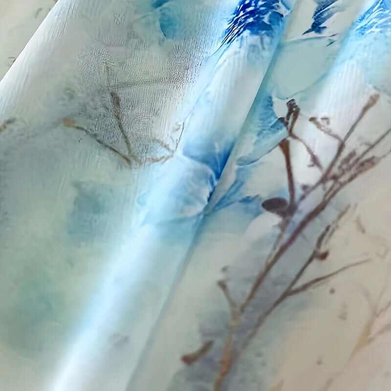 Close-up of blue floral fabric featuring delicate botanical prints, perfect for boho-style clothing.
