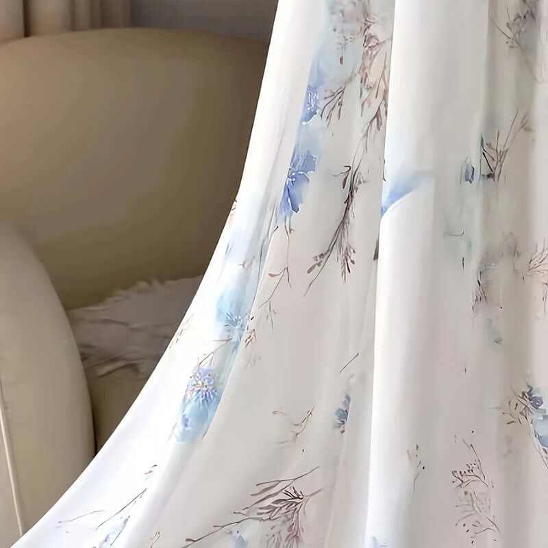 Close-up of floral print fabric on a women's boho maxi dress, showcasing elegant blue designs on a light background.