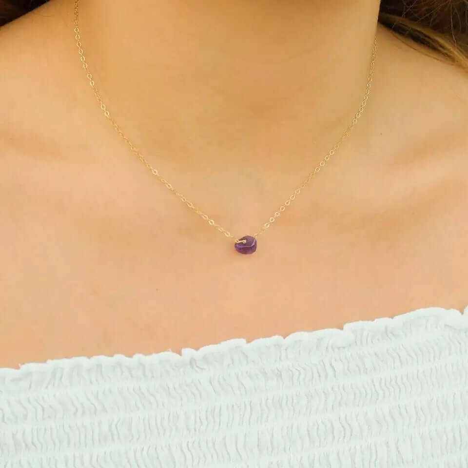 Boho natural elemental stone charm pendant necklace with a purple stone on a gold chain.