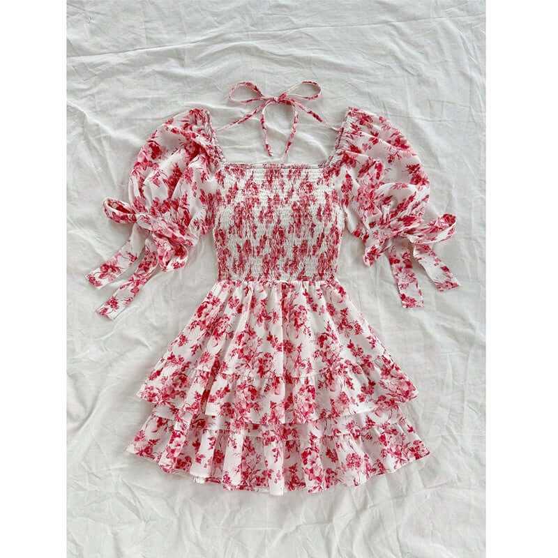 Women's boho floral mini dress with puff sleeves, smocked bodice, and ruffle hem on a light background.
