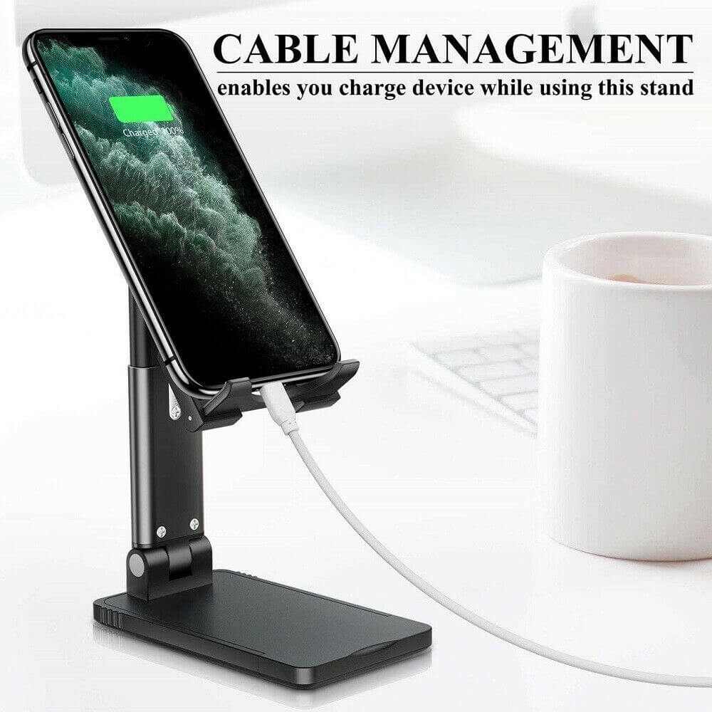 Mobile phone stand with cable management features, allowing device charging while in use on a desk.