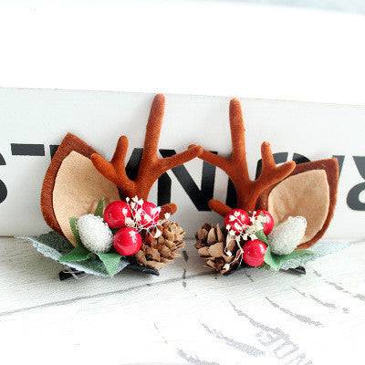 Children's Christmas hair clip with fabric antlers, pinecones, and red berries decoration