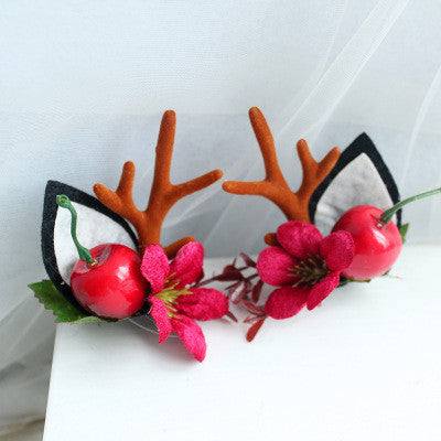 Children's Christmas hair clip with fabric antlers, red cherries, and pink flower decoration