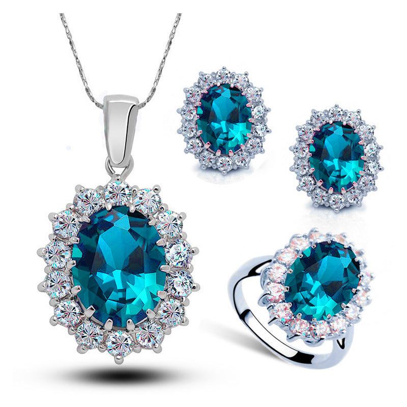 Bridal crystal jewelry set with blue gemstones, earrings, ring, and necklace in silver tone