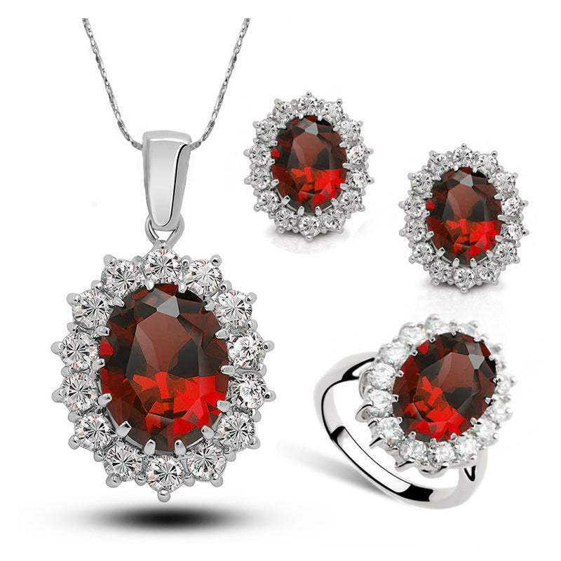 Bridal crystal jewelry set with red oval gemstones surrounded by clear crystals including necklace, earrings, and ring in Korean style copper design