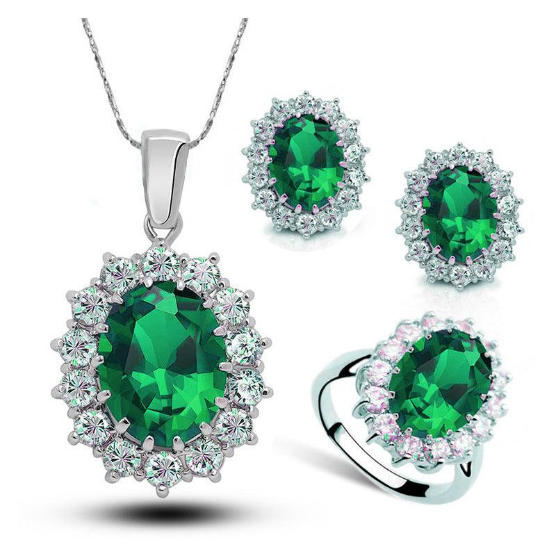 Bridal crystal jewelry set with green oval stones and silver settings including necklace, earrings, and ring.