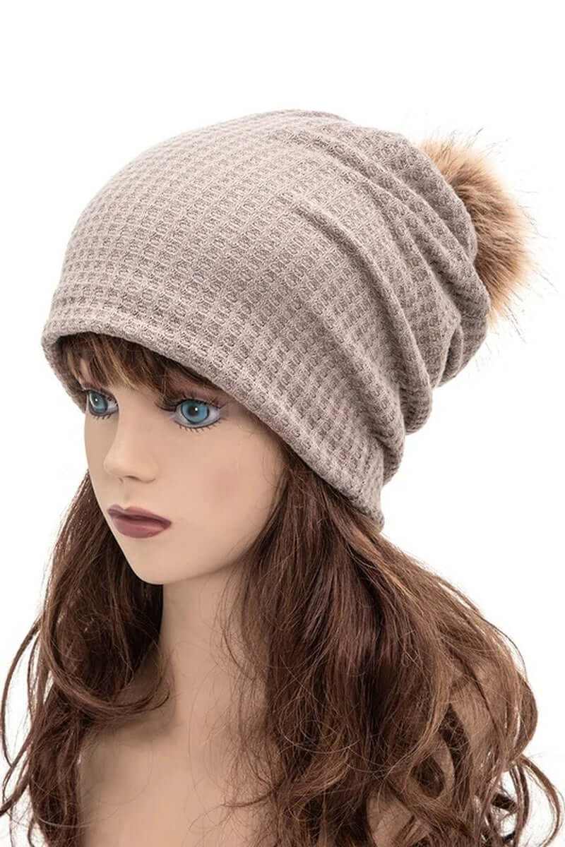 Cotton slouchy beanie with faux pom worn by mannequin, soft winter accessory for warmth and style.