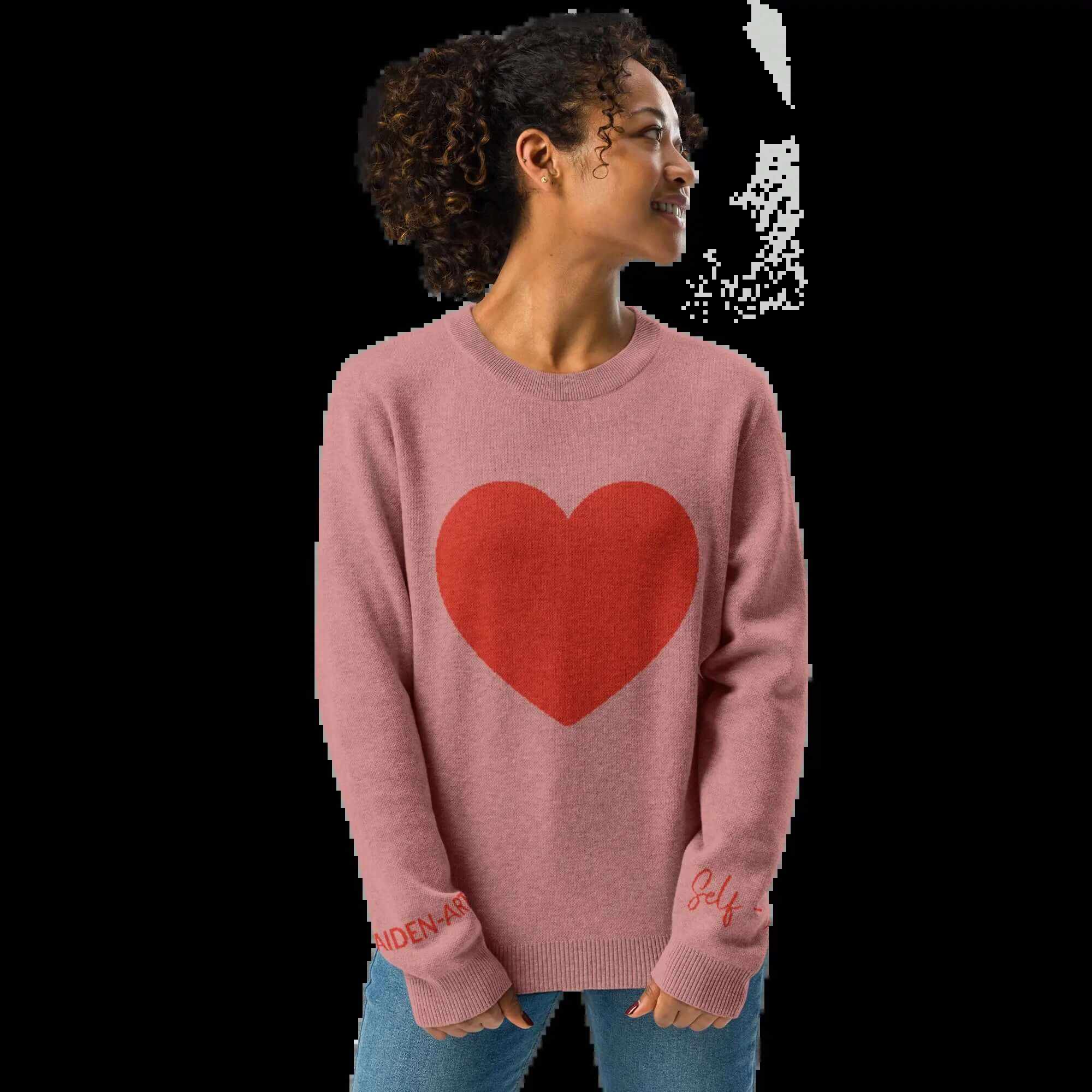 Model wearing a cozy coral heart knit crewneck sweater with a bold red heart design.