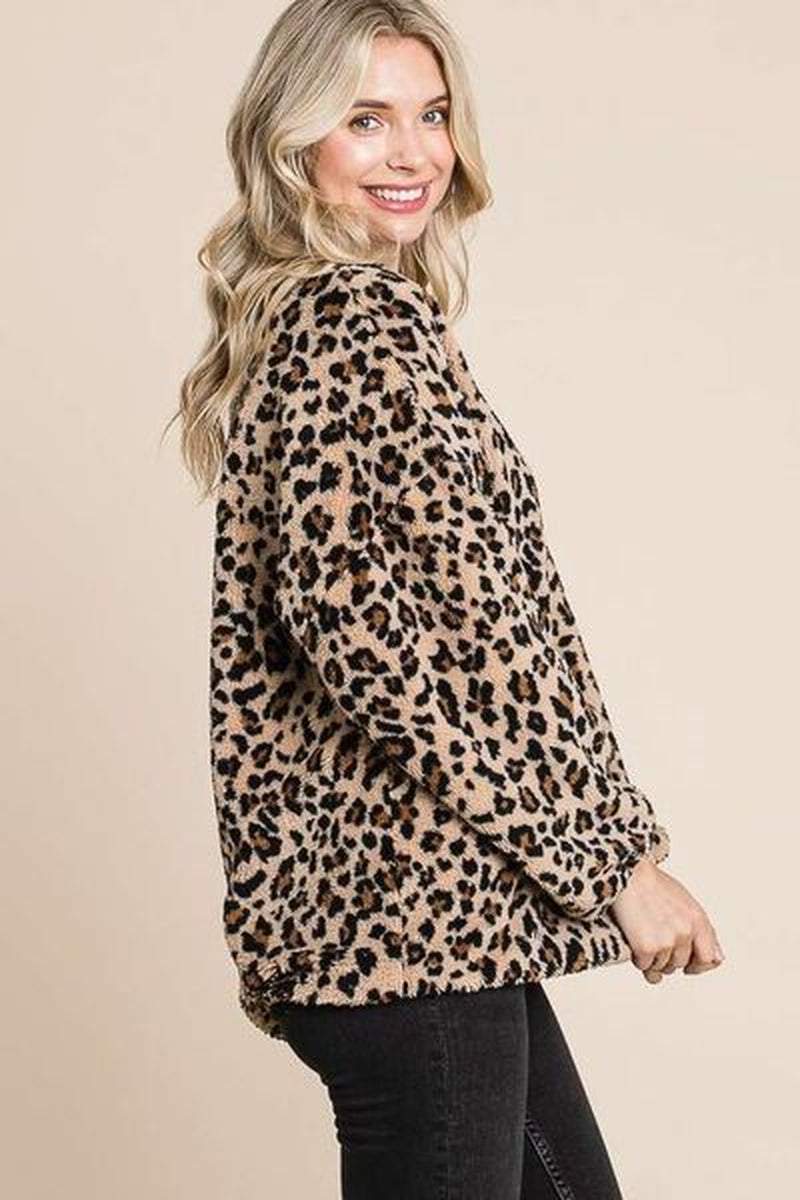 Woman wearing a cozy leopard faux fur round neck top, showcasing a stylish print and luxurious feel.