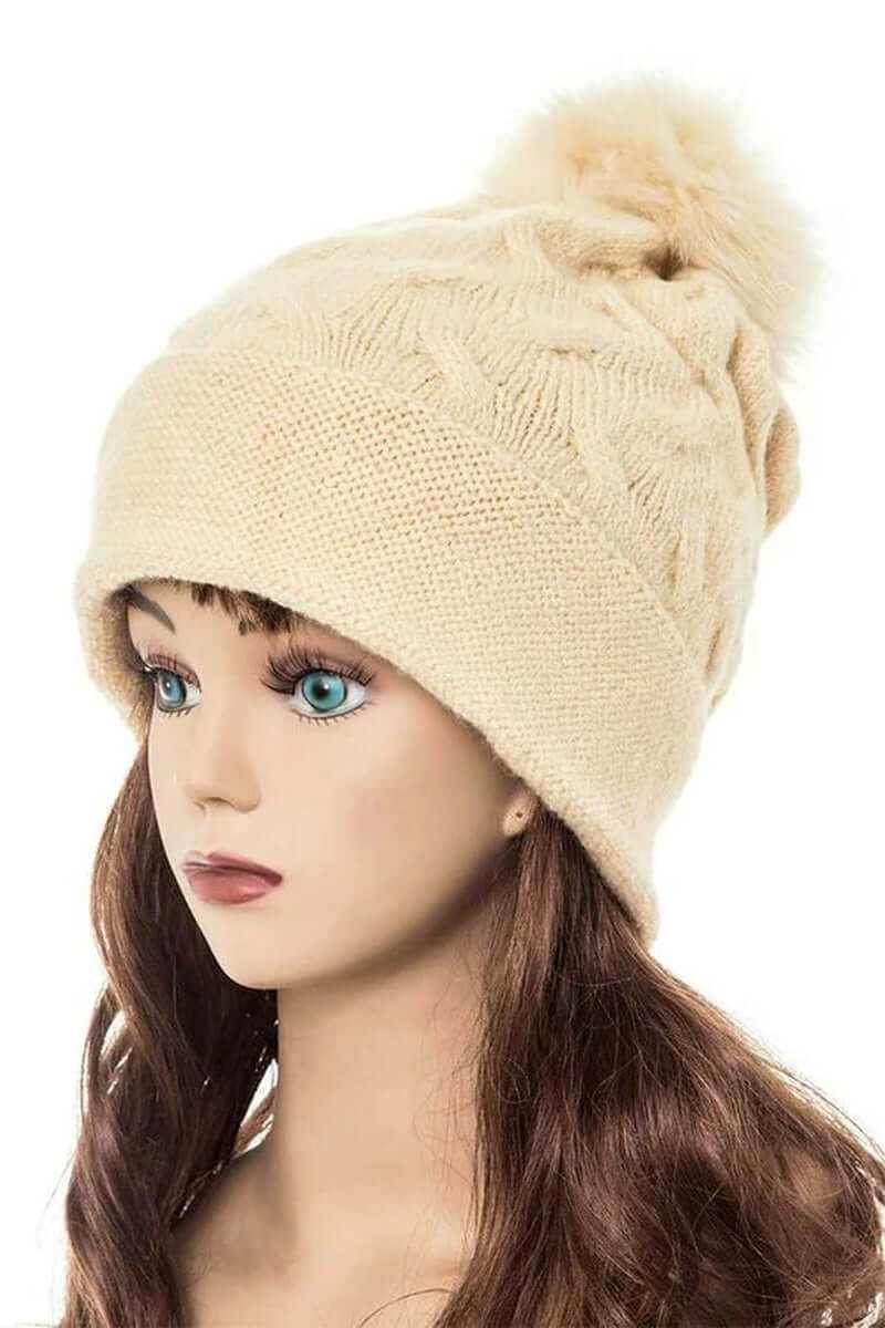 Cuffed slouchy beanie with fur pom in cream color, showcasing stylish knit design and cozy fit for winter wear.