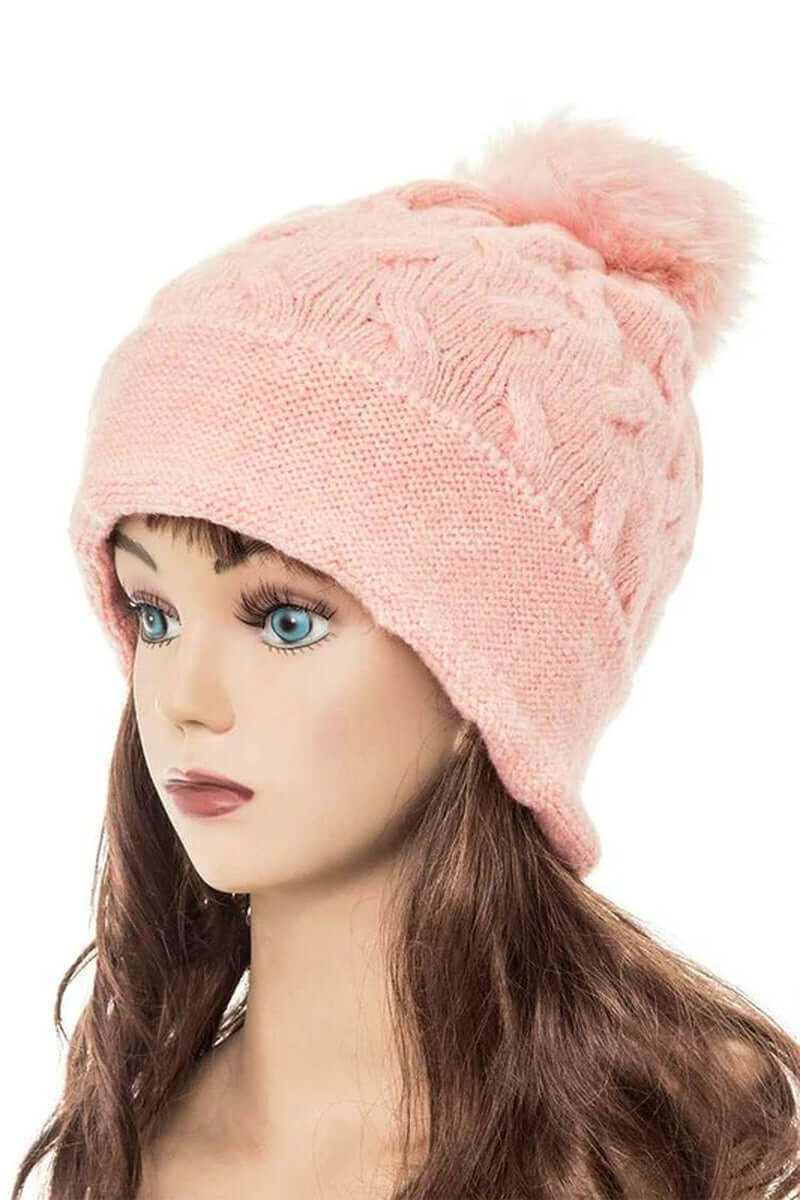 Cuffed slouchy beanie in soft pink with fur pom, perfect for winter fashion and warmth.