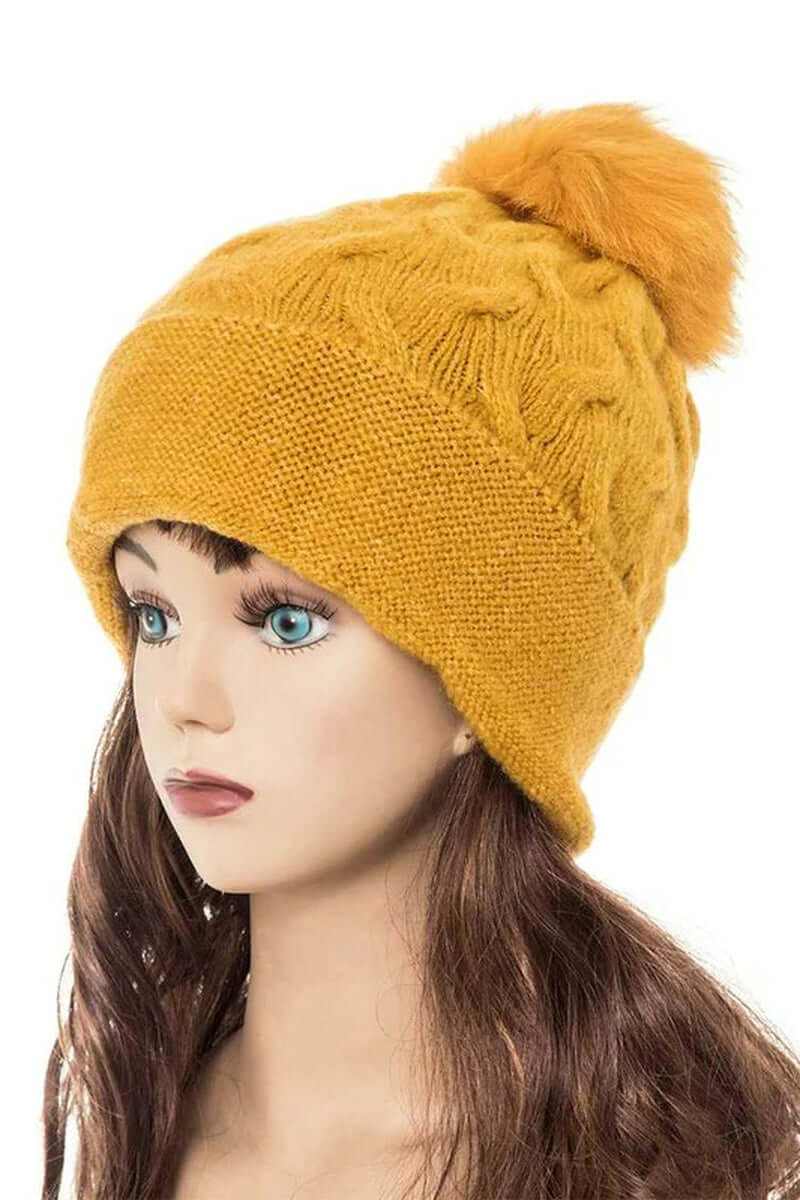 Cuffed slouchy beanie with fur pom in mustard color, showcasing cozy knit and stylish design for winter fashion.