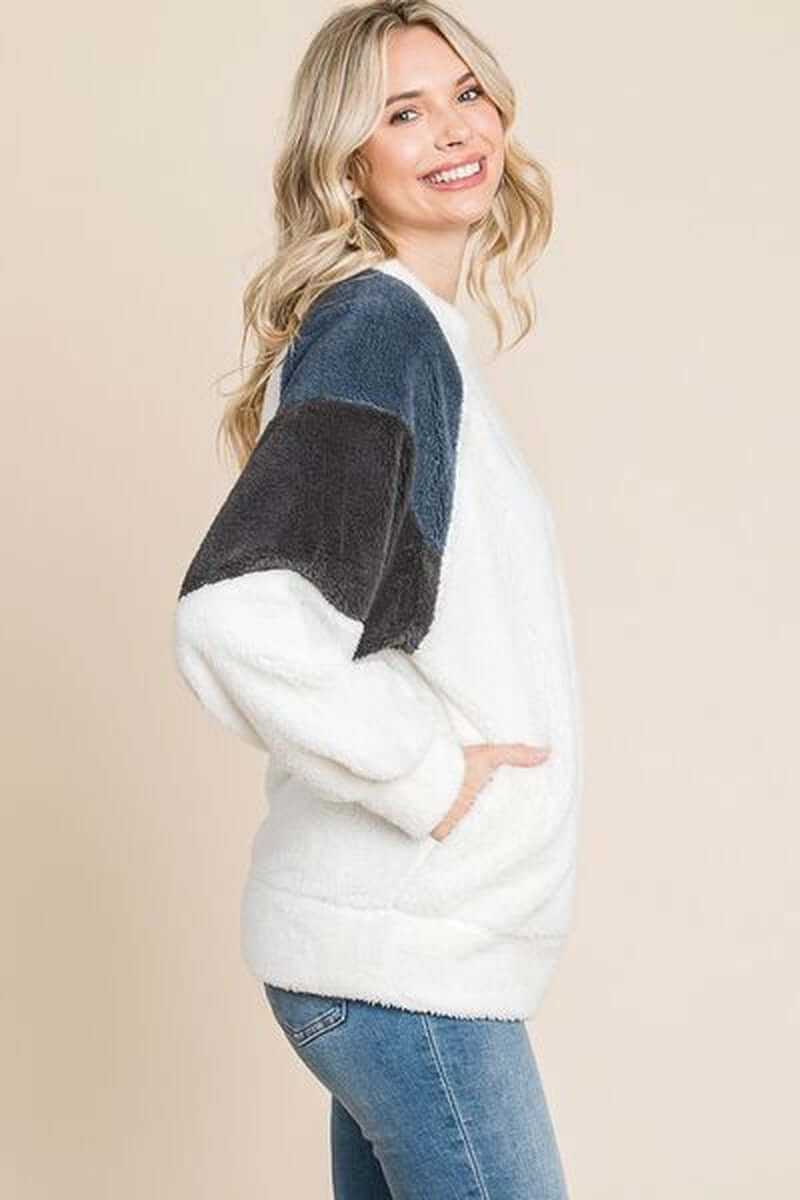 Side view of a woman wearing a Color Block Faux Fur Raglan Sleeve Sweatshirt, showcasing stylish faux fur and a cozy design.
