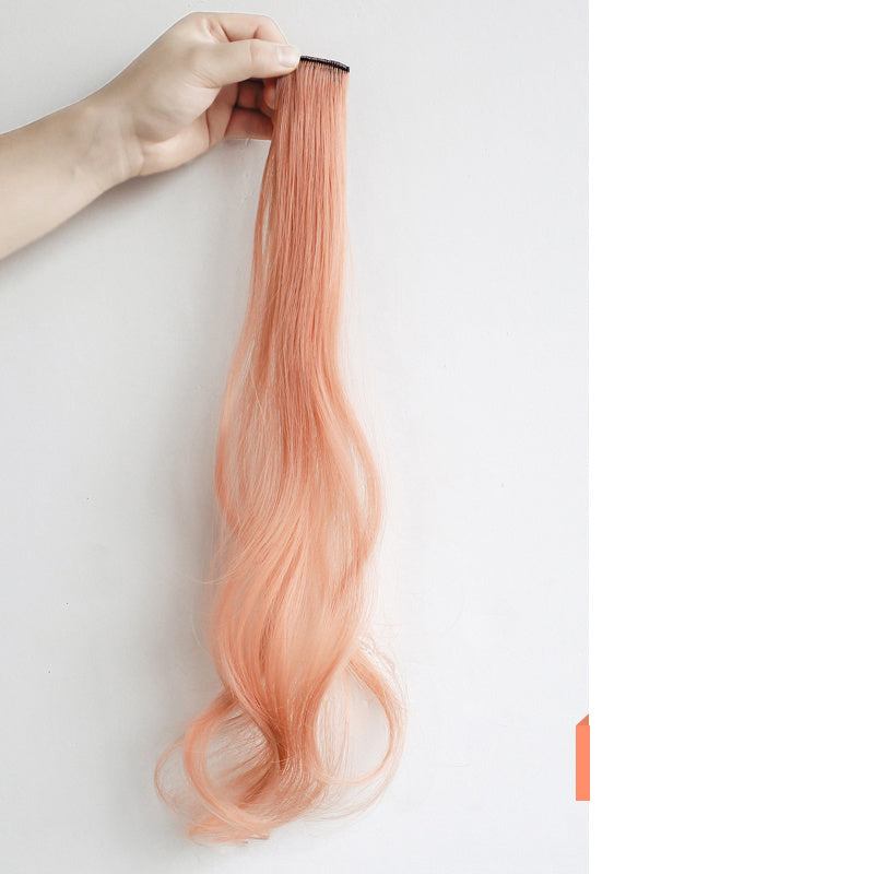Hanging ear dyed curly hair extension in peach color held by hand