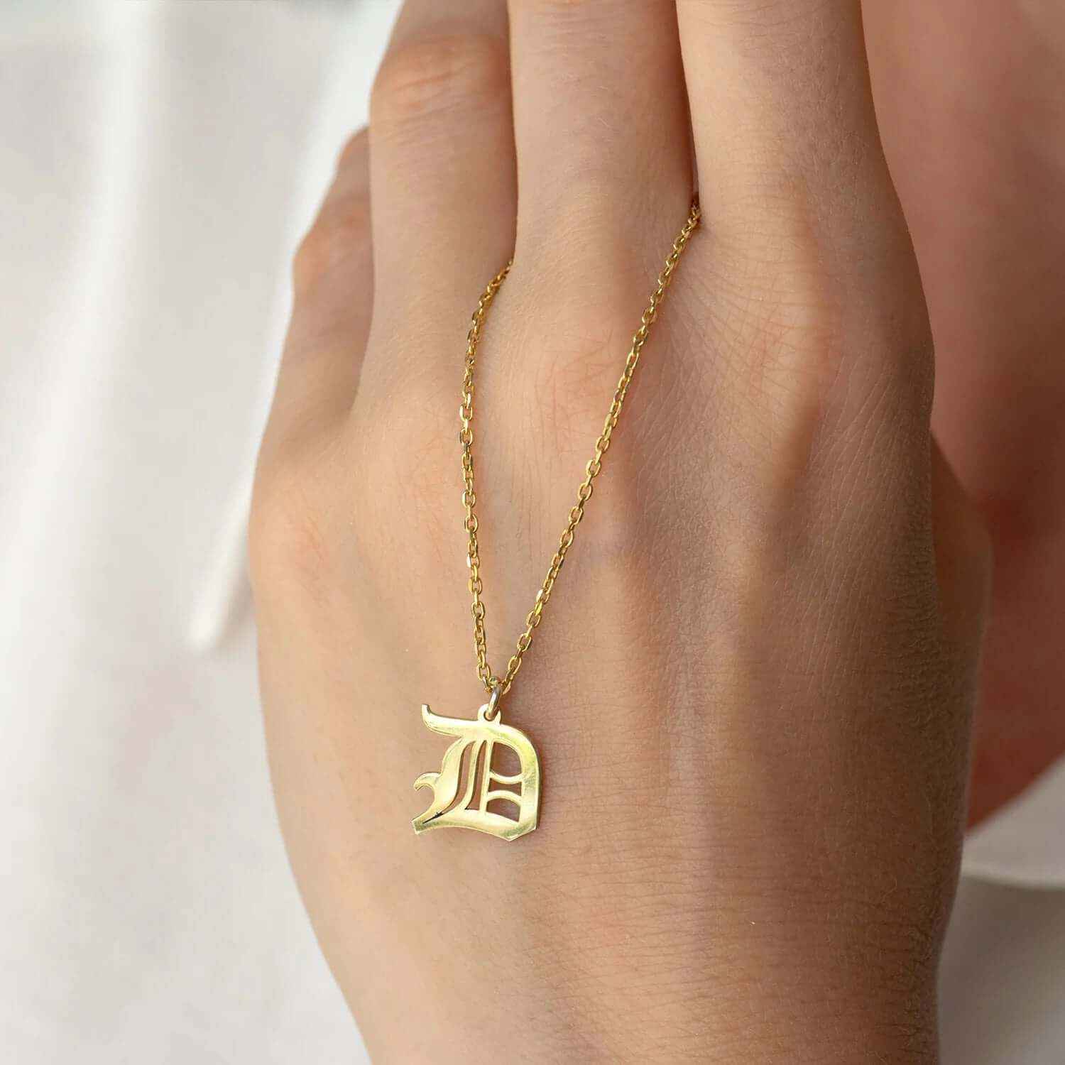 Custom Gothic initial necklace in 18K gold plating, showcasing a distinctive 'D' letter on a delicate chain.