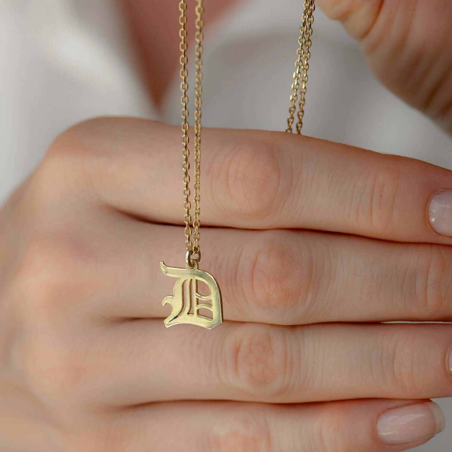 Hand holding a Custom Gothic Initial Necklace with 'D' pendant in 18K Gold Plated, showcasing personalized style and elegance.