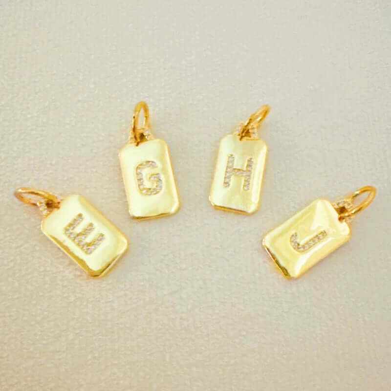 Custom square initial charms in gold plating, featuring sparkly letters G, H, J, and W for personalized jewelry.