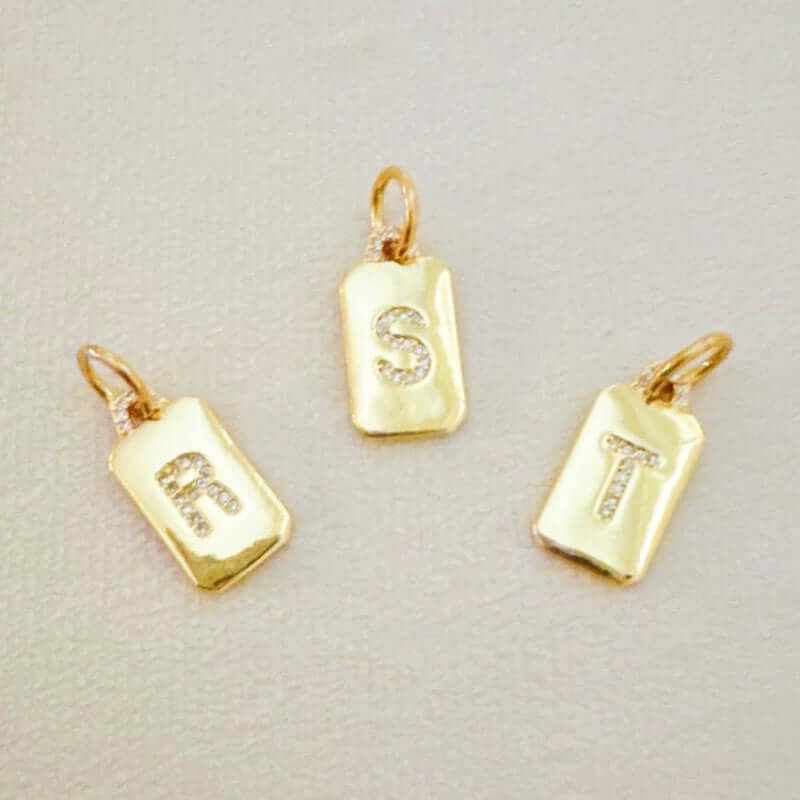 Custom personalized gold initial clip charms featuring sparkling letters R, S, and T on sleek designs.