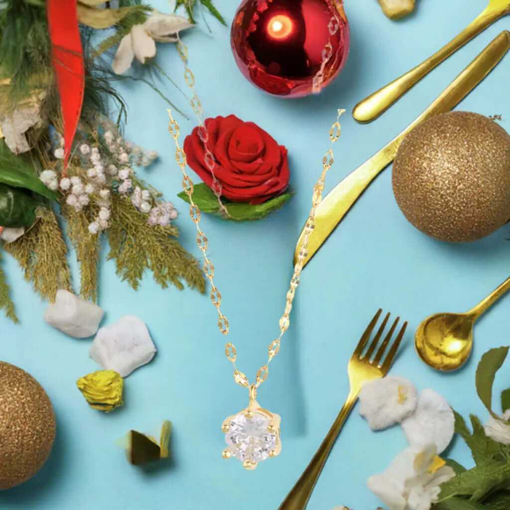 Dainty elegant 14K gold plated solitaire necklace with cubic zirconia, surrounded by holiday decor and festive elements.