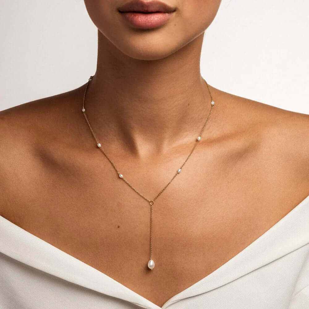 Model wearing a dainty fresh water pearl necklace with a gold plated chain, showcasing timeless elegance.