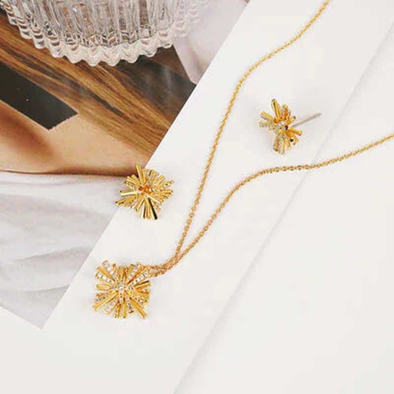 Dainty starburst gold-plated jewelry set featuring a pendant necklace and matching earrings, stylishly presented.