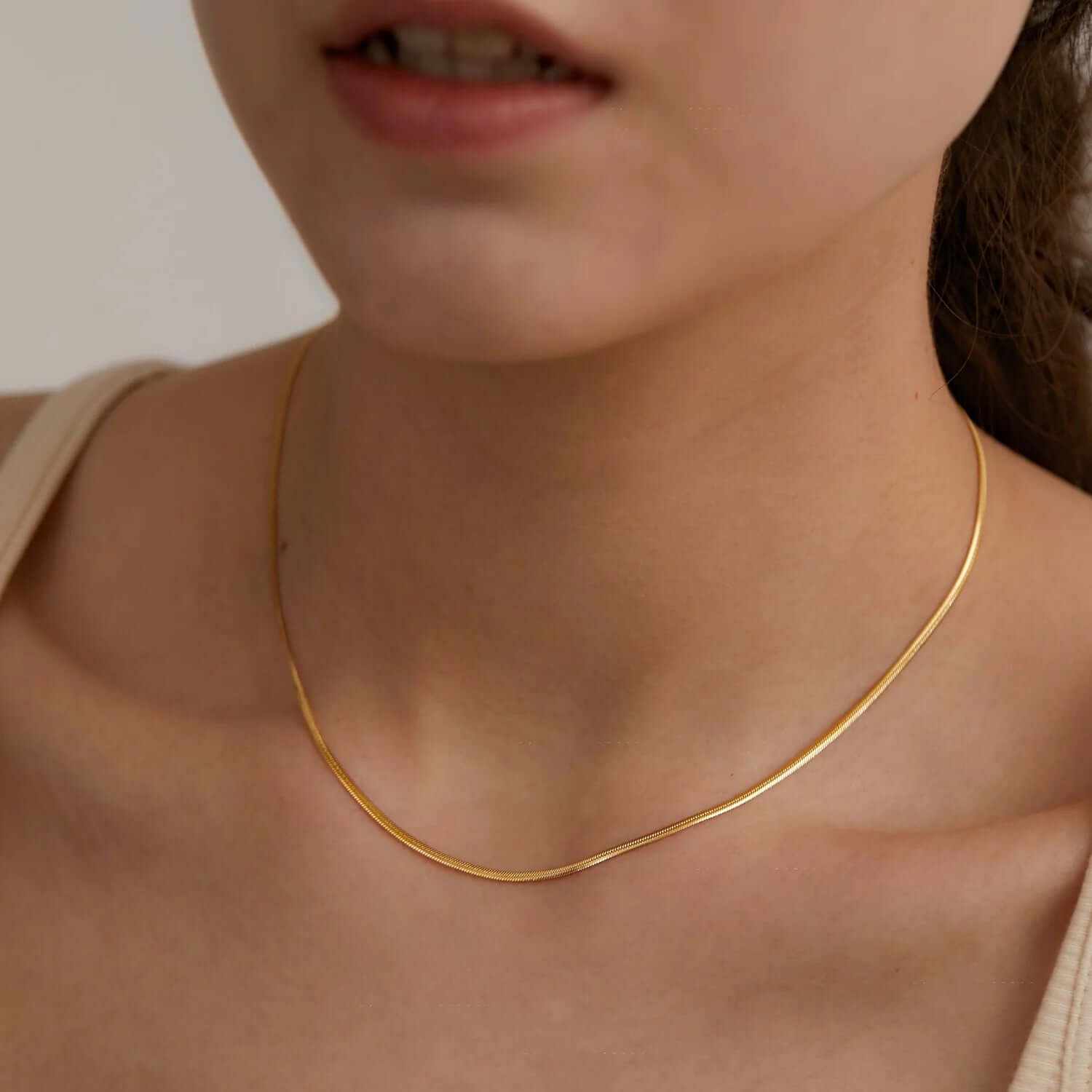 Dainty trendy gold plated choker necklace worn elegantly on a model's neck, showcasing timeless sophistication.
