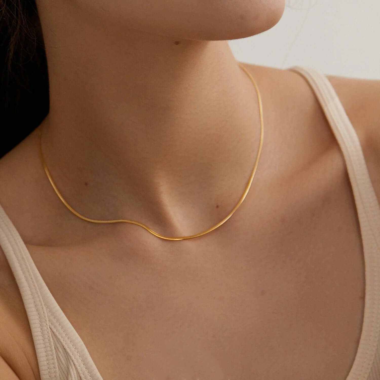 Dainty gold plated layered choker necklace elegantly displayed on a model's neck, showcasing timeless sophistication.