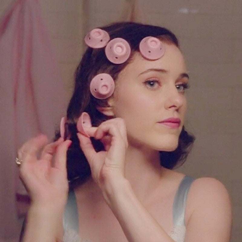 Woman using pink silicone hair curlers for damage-free styling hairstyle