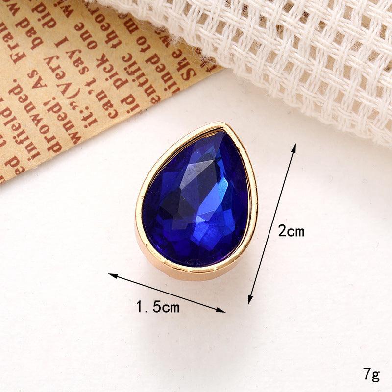 Bright blue teardrop gem with a gold setting, measuring 2cm by 1.5cm, ideal for jewelry design or embellishments.