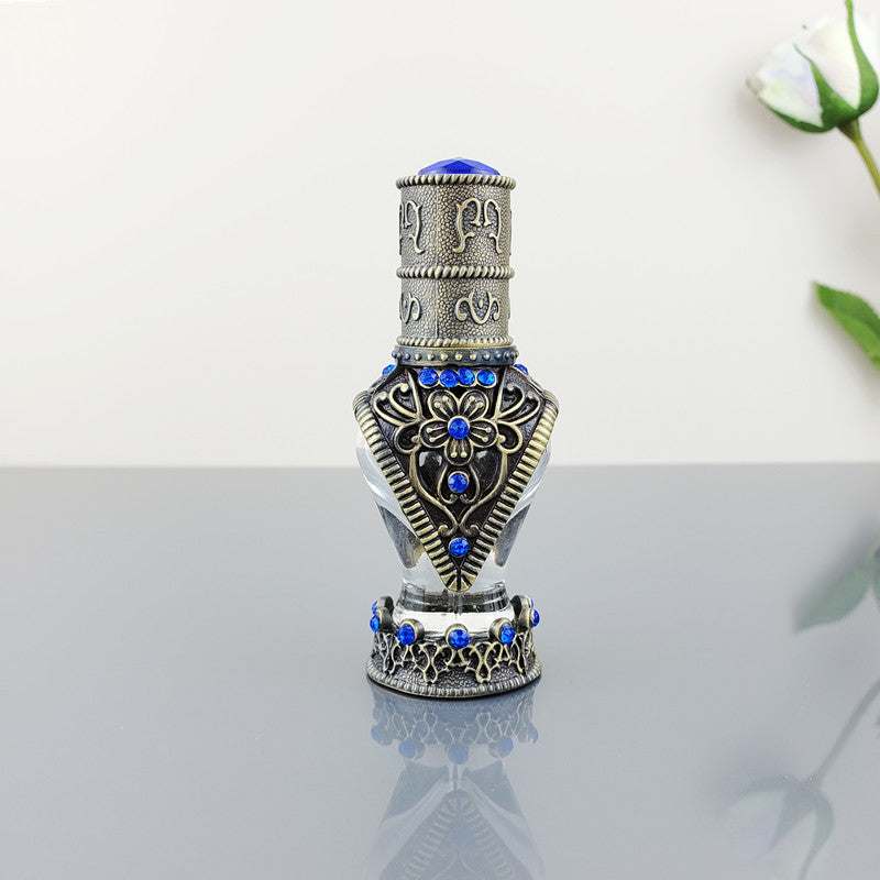 Decorative vintage cosmetic bottle with blue artificial stones and intricate alloy design