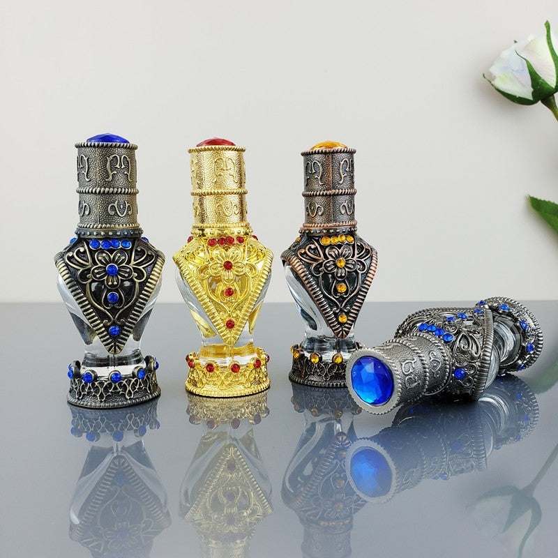 set of empty decorative vintage cosmetic bottles with intricate metal and glass design in gold, silver, and blue colors