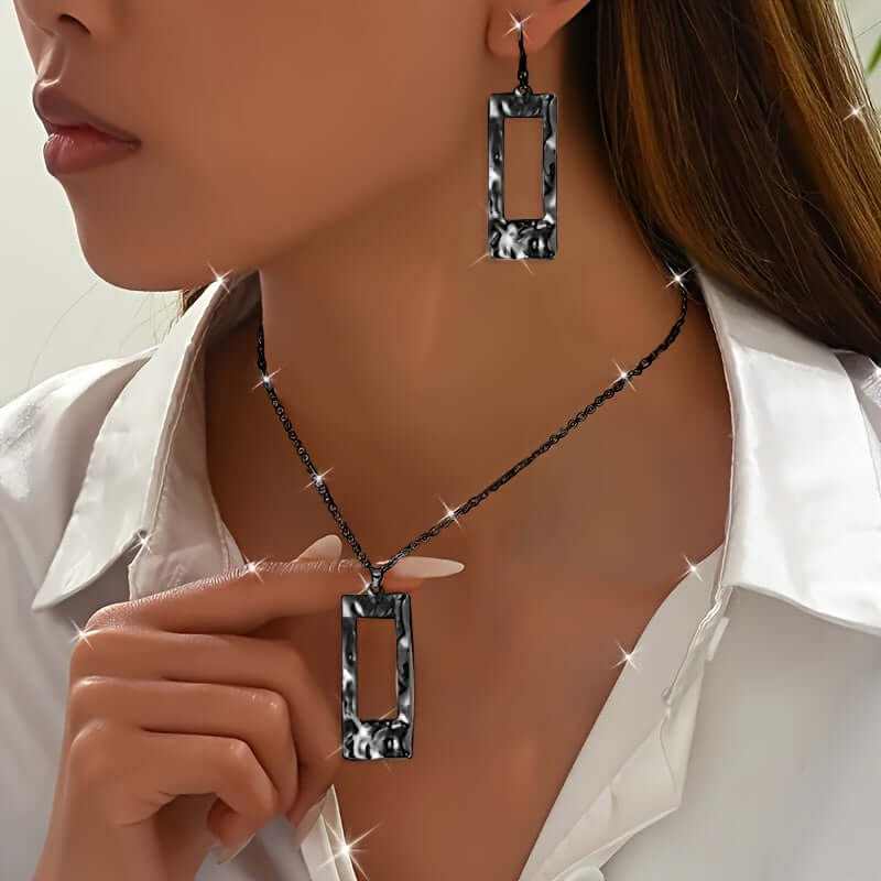 close-up of woman wearing eco-friendly geometric rectangular black metal jewelry set with necklace and matching earrings
