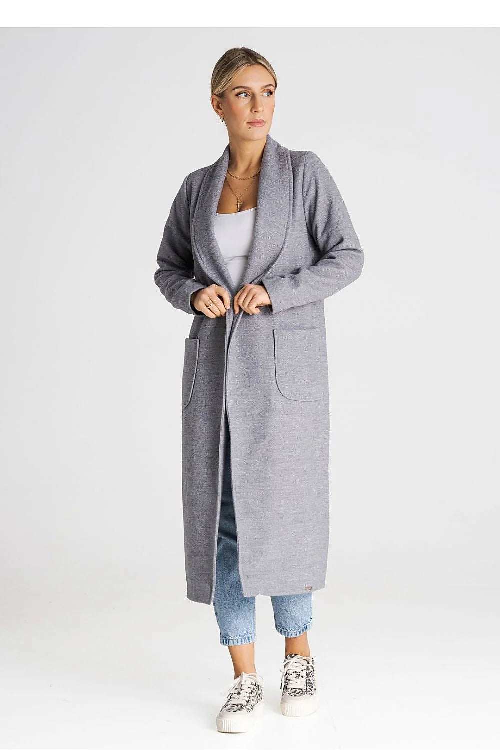 Elegant gray long cardigan featuring large pockets and open front, styled with casual jeans and sneakers.