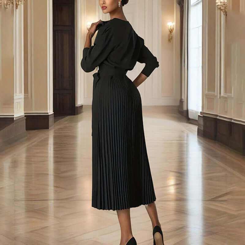 Elegant women’s black pleated maxi dress with tie waist, showcasing a sophisticated back view in a luxurious interior.