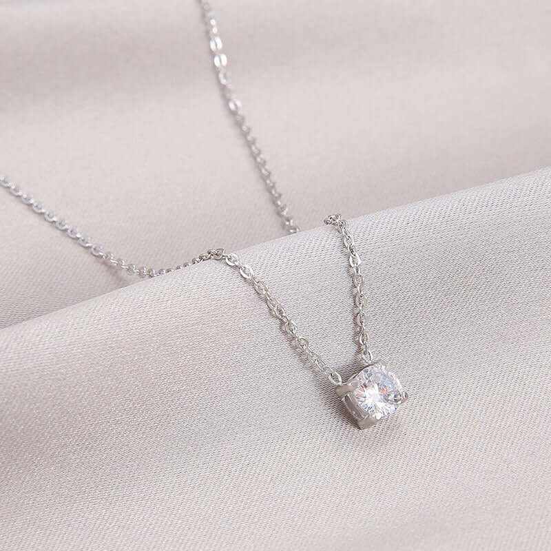 Elegant Zircon Birthstone Necklace on soft fabric, featuring a sparkling round zircon pendant.