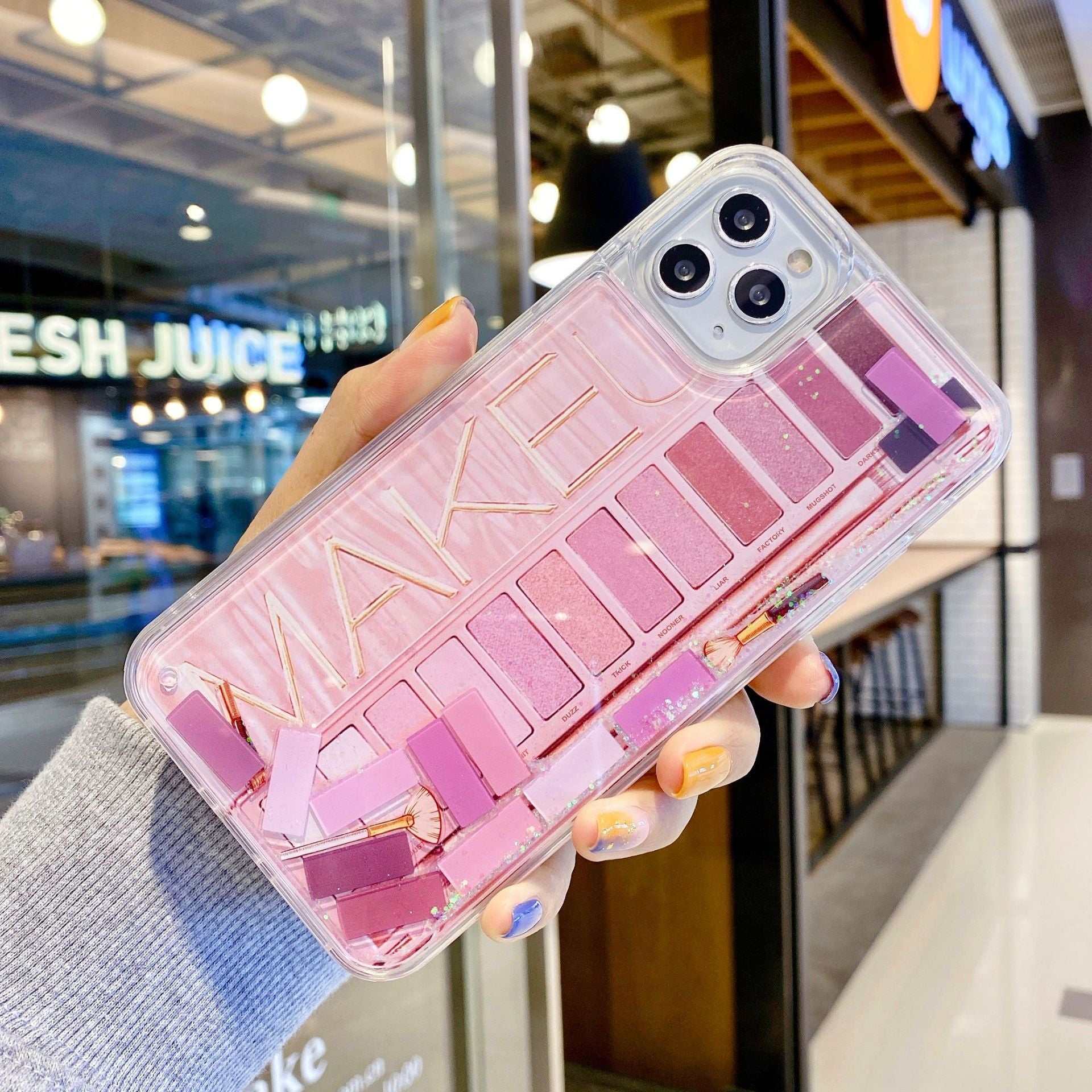 Clear iPhone case with pink eyeshadow palette cosmetics design and gold lettering, anti-fall plastic cover