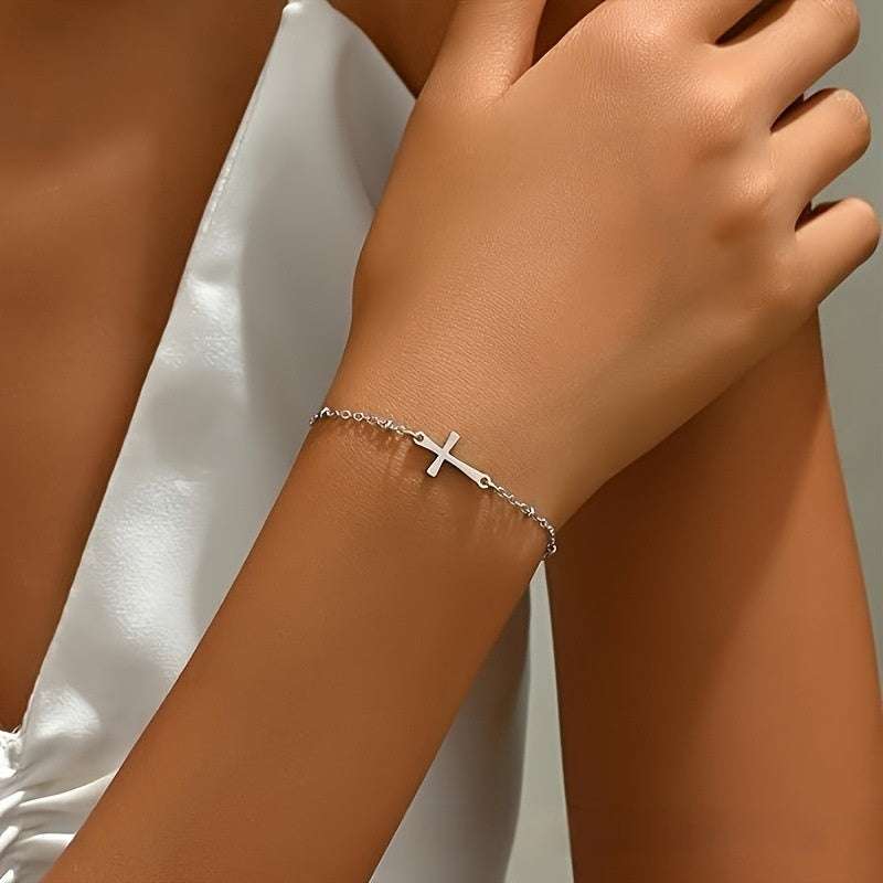 Unisex silver cross bracelet with geometric design and delicate chain on wrist