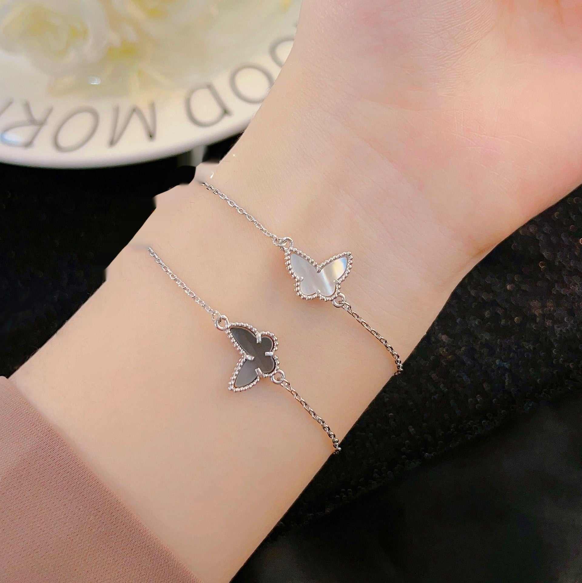 Unisex copper butterfly bracelet with white and gray shell design on wrist, electroplated finish