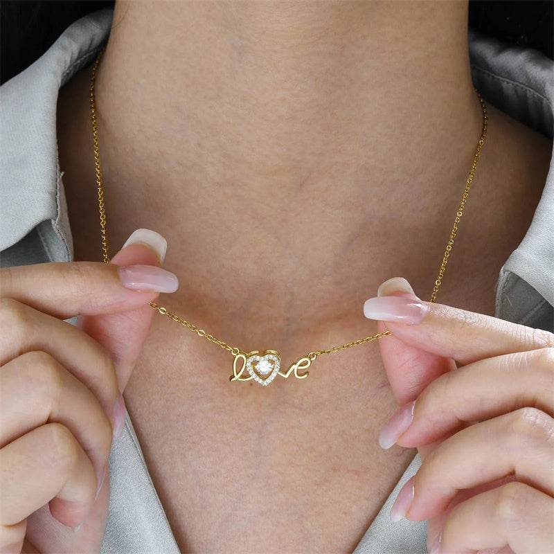 Close-up of gold fashion clavicle chain necklace with "love" pendant and heart detail worn on neck