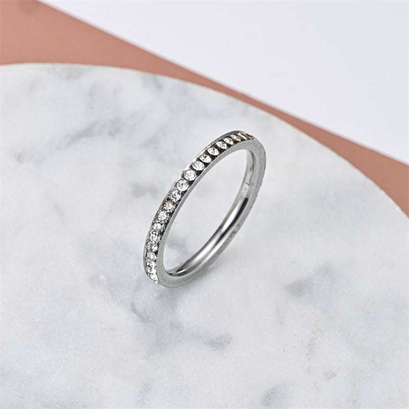 Fashionable elegant stainless steel titanium steel ring with embedded crystals on marble surface