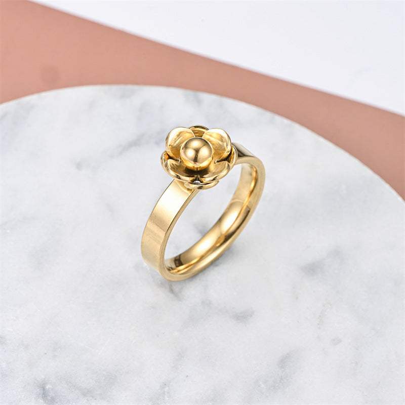 Fashionable elegant stainless steel gold flower ring on marble surface