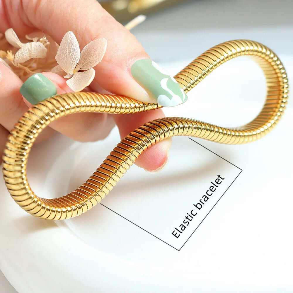 Flexible gold-plated elastic bangle held in hand, showcasing its stylish design and comfortable fit.