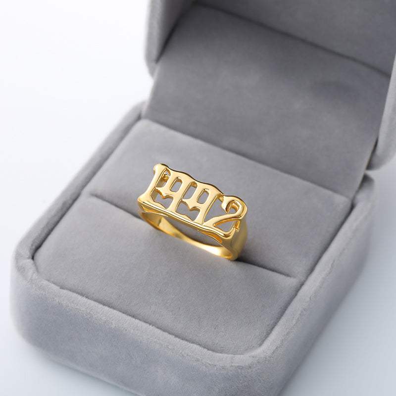 Gold futuristic and vintage cyberpunk style ring with embossed numbers in gray velvet box