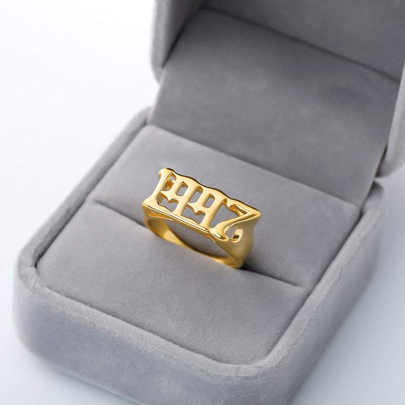Gold futuristic and vintage cyberpunk style stainless steel ring with numerical design in gray velvet box