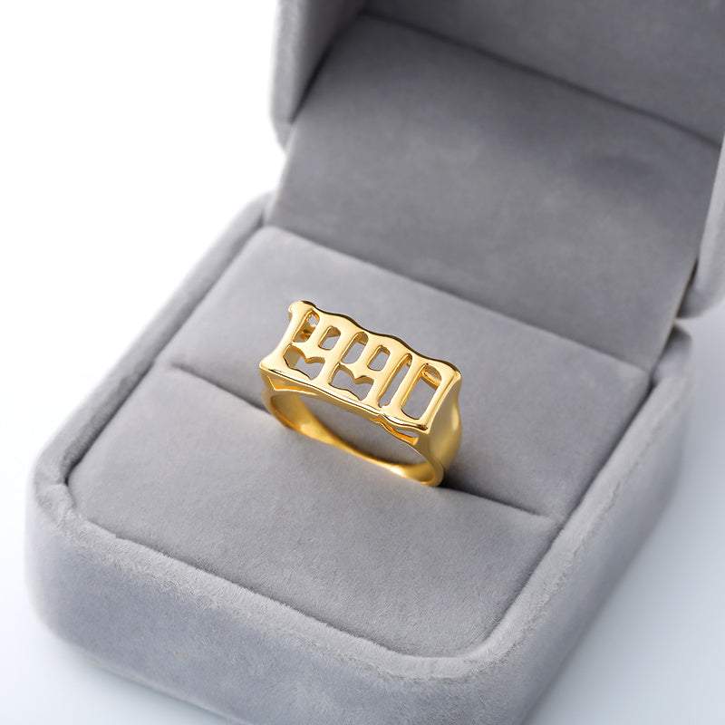 Gold futuristic vintage cyberpunk style stainless steel ring with "1990" design in gray velvet jewelry box