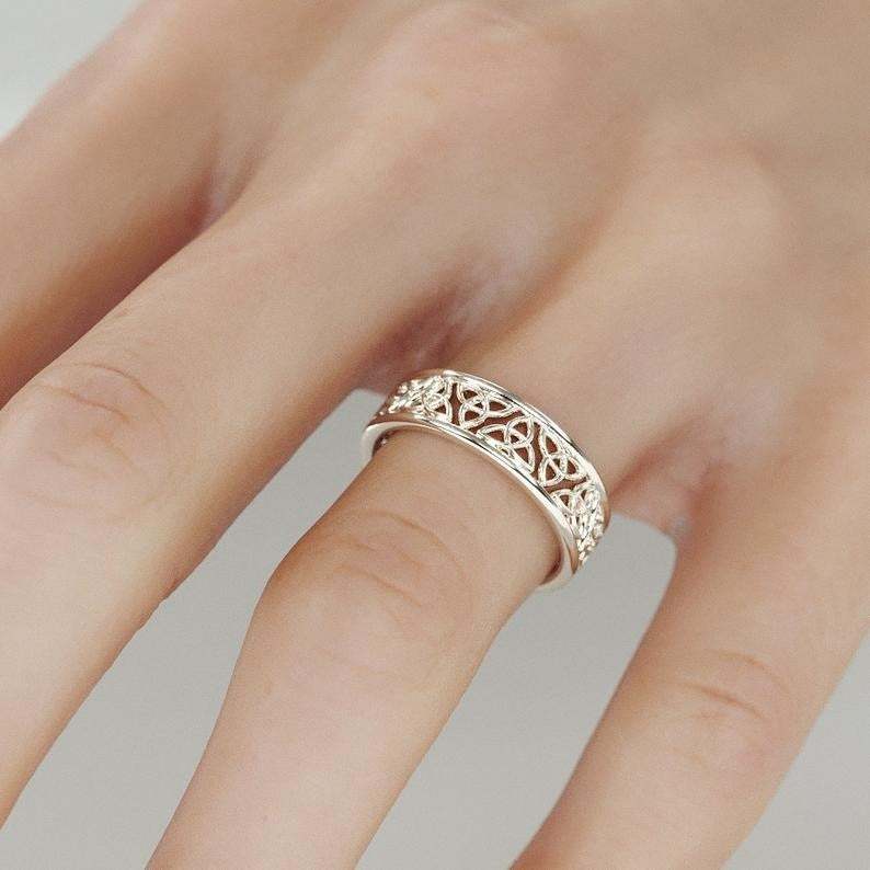 Close-up of a woman's hand wearing a white alloy hollow flower ring with electroplated finish