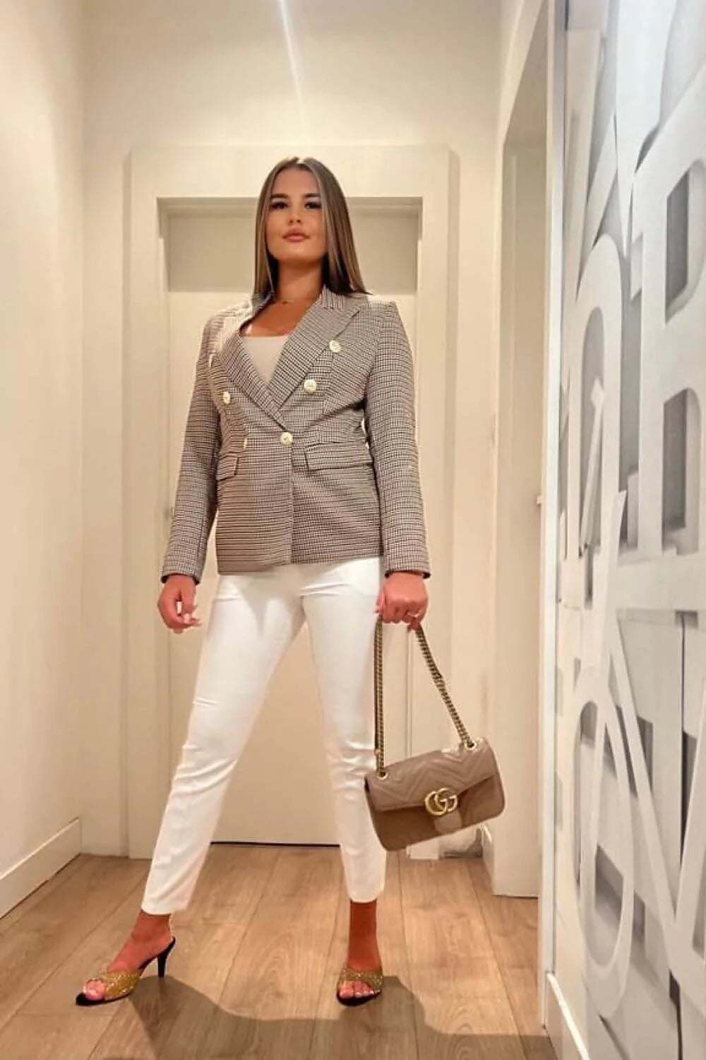 Model wearing the Jacket Model 193070 Cabba, a stylish blazer with an elegant cut, paired with white trousers.