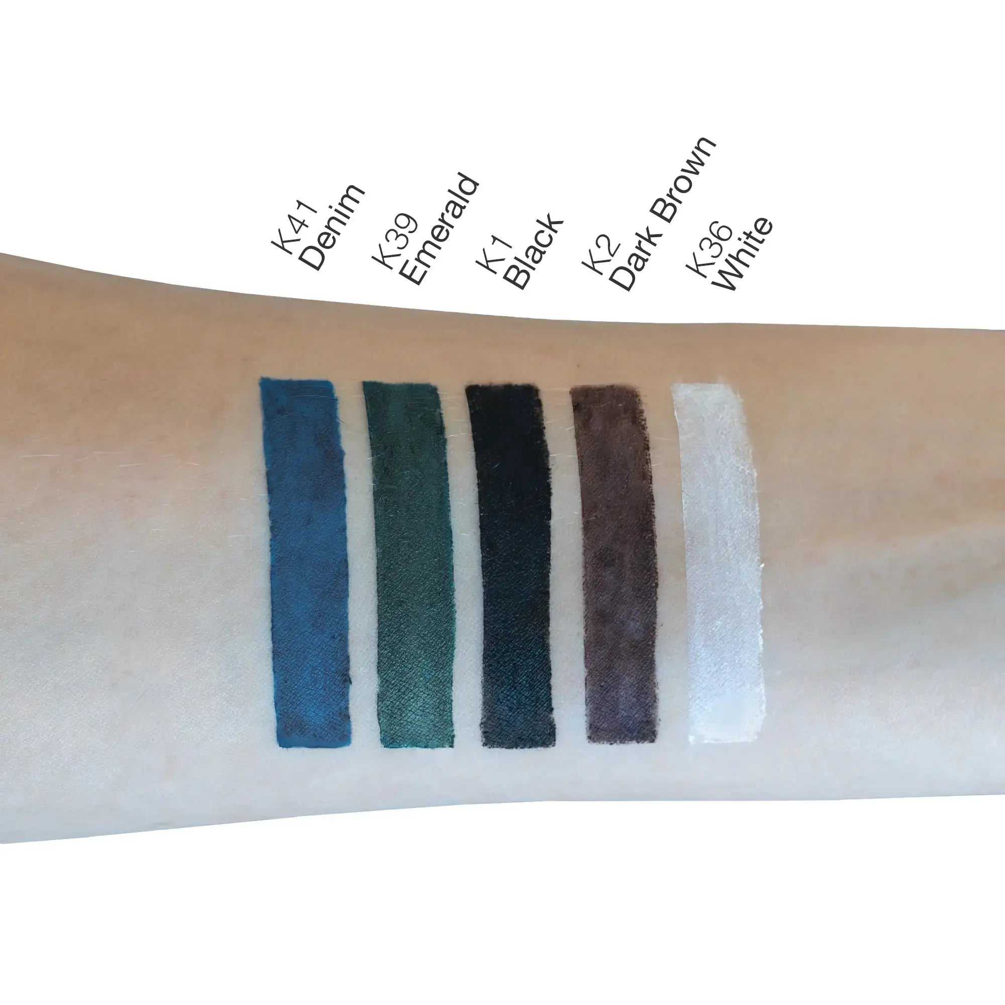 Swatches of Khol Eyeliner in Denim, Emerald, Black, Dark Brown, and White on a forearm.