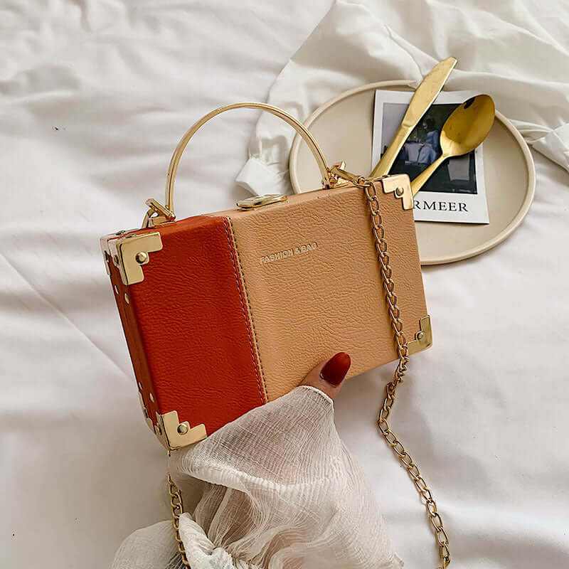Elegant two-tone handle clutch purse with chain detail, ideal for party outfits and stylish events.